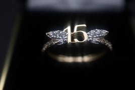 14 K Gold Ring (Quinceanera) ring with "15" in the middle and two CZ tree leaves.  Weight: 1.8 G  Size: 6.5