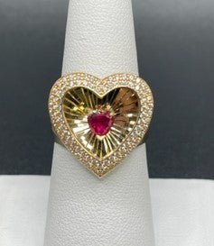 14 K Gold Ring A heart-shaped ring with Cubic Zirconia stones all around and a heart-shaped ruby stone in the middle.   Size: 7 5.5 G